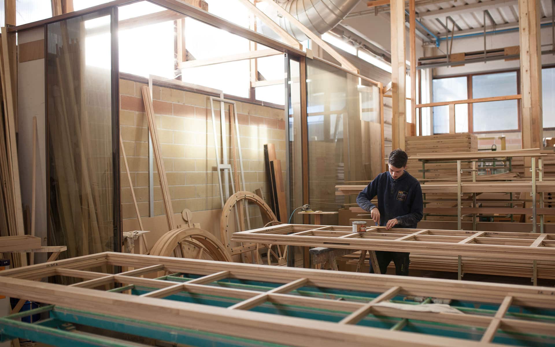 ragazzo realizza una finestra in legno mixlegno